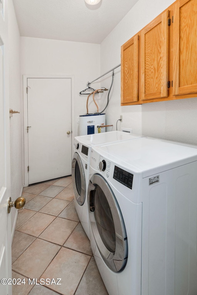 laundry room with cabinets, electric water heater, independent washer and dryer, and light tile patterned flooring