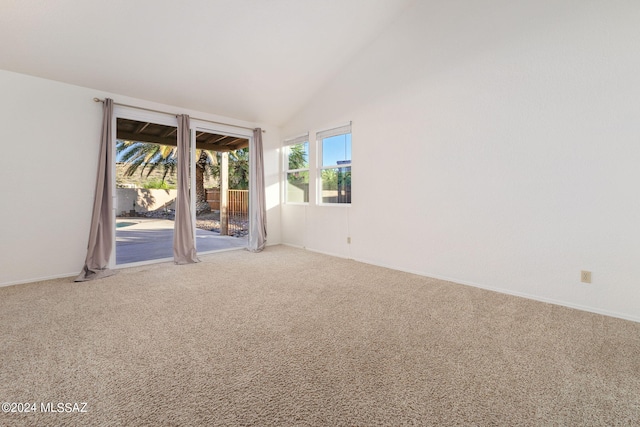 empty room with high vaulted ceiling and carpet