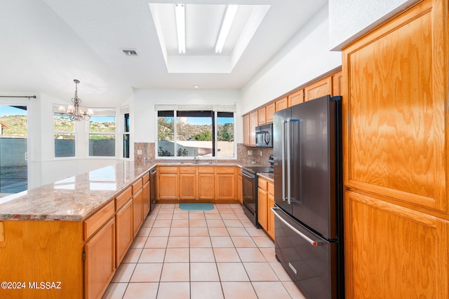 kitchen featuring a notable chandelier, kitchen peninsula, decorative backsplash, black appliances, and light tile patterned floors