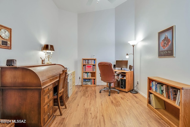 home office with ceiling fan and light hardwood / wood-style flooring