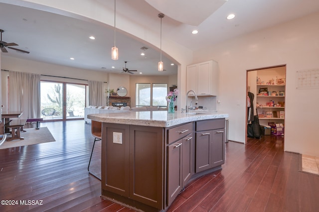 kitchen with hanging light fixtures, white cabinetry, ceiling fan, and dark wood-type flooring