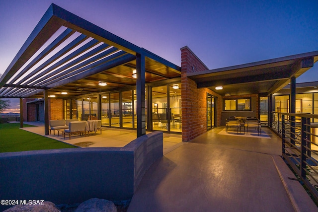 back house at dusk featuring an outdoor hangout area and a patio area