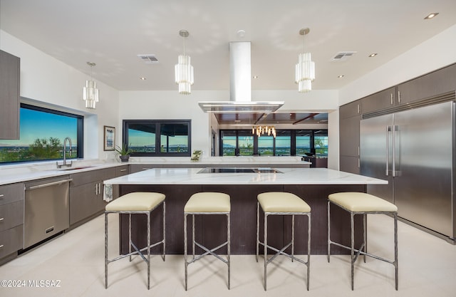 kitchen with a large island, appliances with stainless steel finishes, island exhaust hood, and a breakfast bar