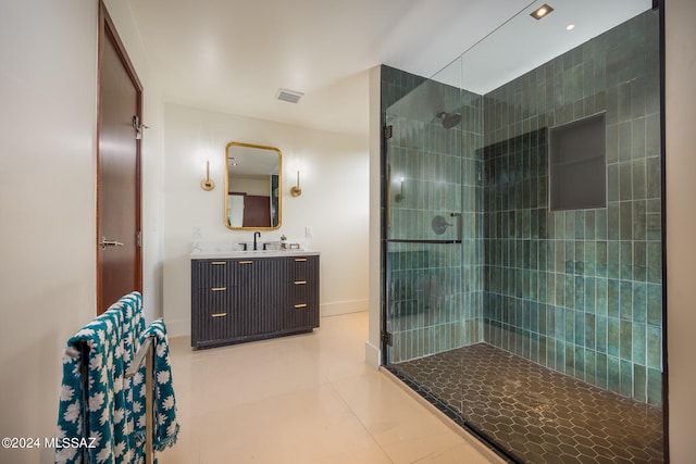 bathroom with tile patterned flooring, vanity, and tiled shower