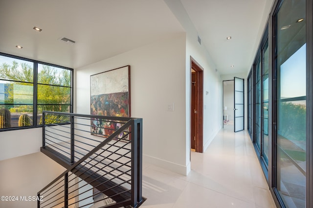 hall with expansive windows and light tile patterned flooring