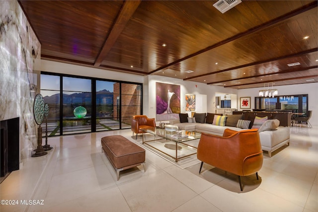 living area with visible vents, beam ceiling, wood ceiling, and an inviting chandelier