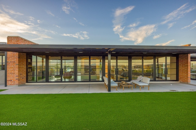 back of house featuring a lawn and a patio area