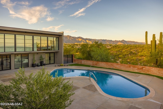 view of swimming pool with a mountain view and a patio