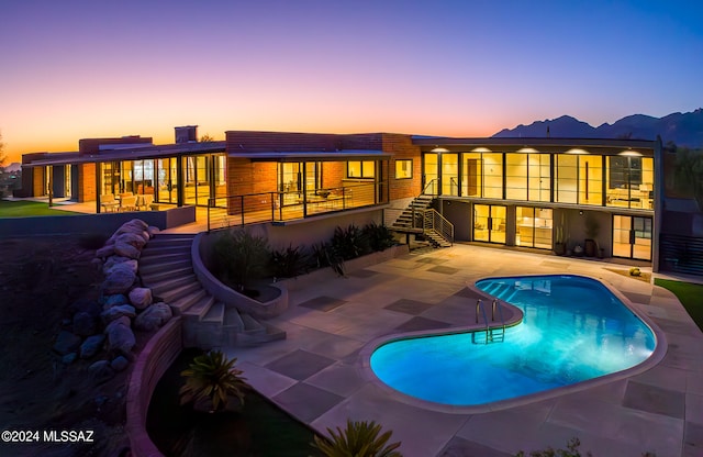 pool at dusk with a patio