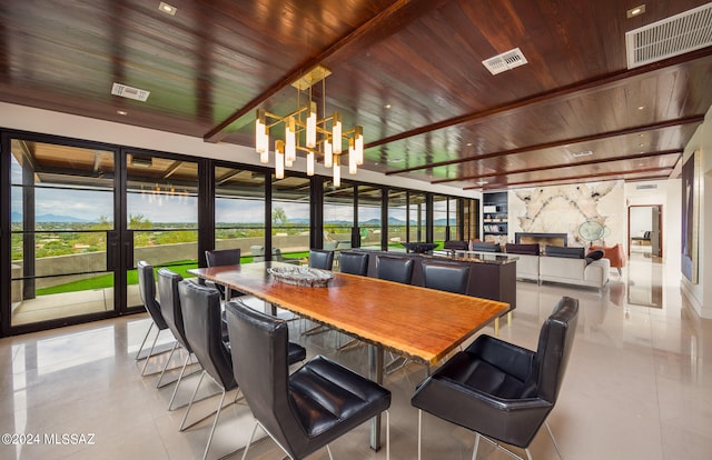 dining space featuring a chandelier, wooden ceiling, and a fireplace