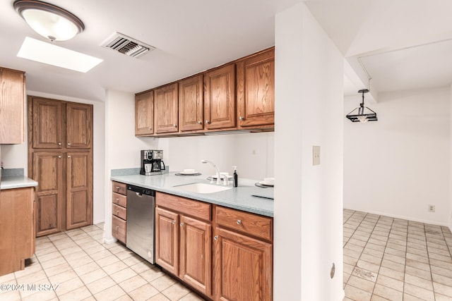 kitchen with dishwasher, light tile patterned floors, decorative light fixtures, and sink