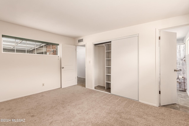 unfurnished bedroom with carpet and a closet