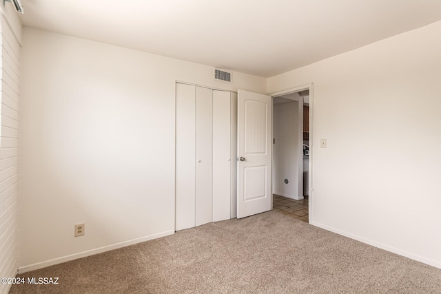 unfurnished bedroom featuring carpet floors and a closet