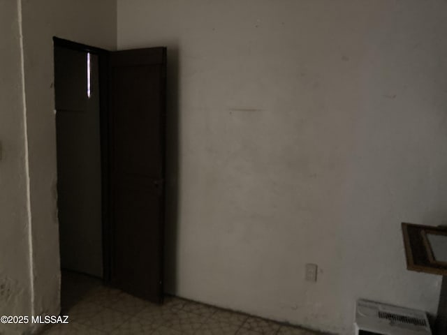 unfurnished room featuring heating unit