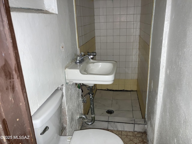 bathroom with tile patterned flooring, toilet, and sink