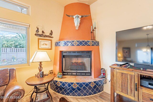 living room with hardwood / wood-style floors and a tiled fireplace