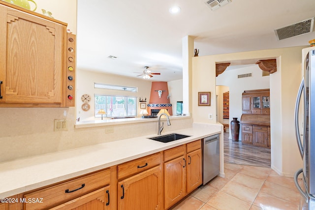 kitchen with sink, appliances with stainless steel finishes, light wood-type flooring, and ceiling fan