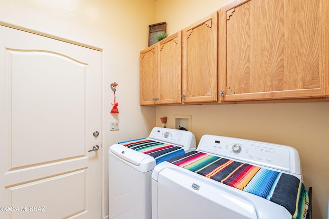 clothes washing area featuring cabinets and washing machine and dryer