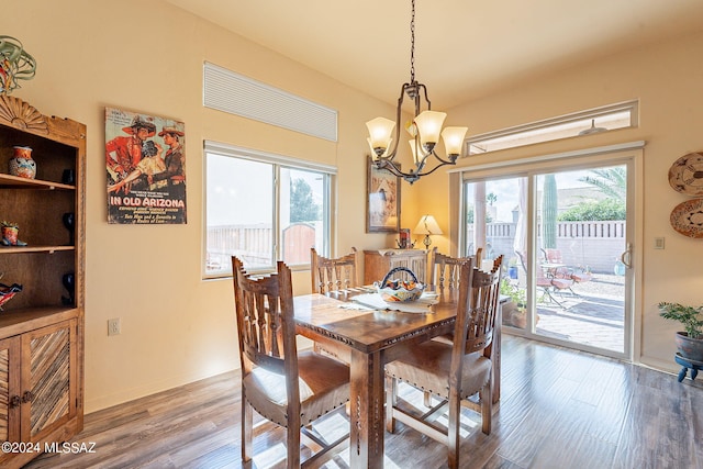 dining room with hardwood / wood-style flooring and an inviting chandelier