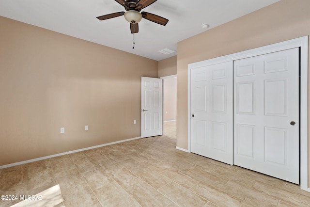 unfurnished bedroom with ceiling fan and a closet