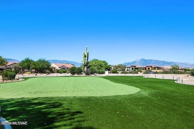 view of community with a mountain view and a lawn