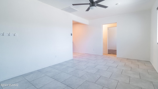 tiled empty room featuring ceiling fan