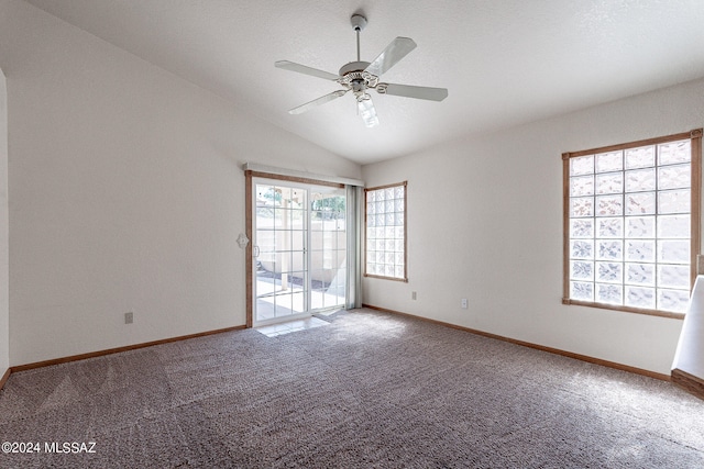 unfurnished room featuring ceiling fan, vaulted ceiling, carpet, and a healthy amount of sunlight