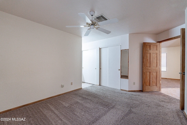 unfurnished bedroom with ceiling fan, light colored carpet, and a closet