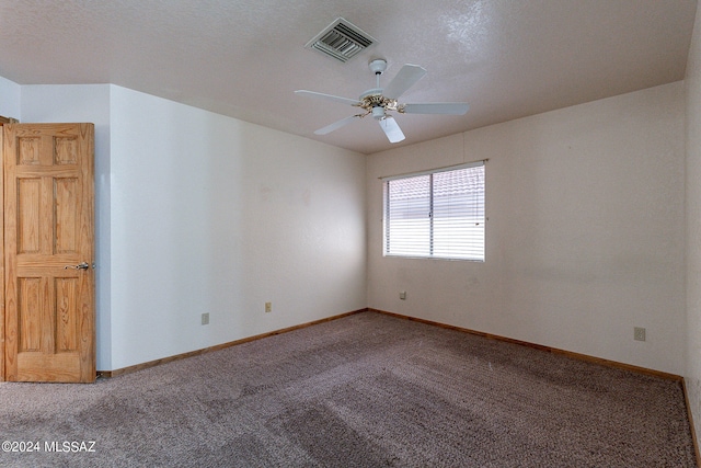 carpeted spare room with a textured ceiling and ceiling fan