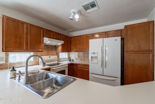 kitchen featuring a healthy amount of sunlight, white appliances, backsplash, and sink