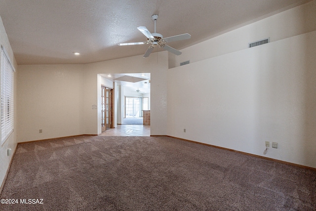 empty room with a textured ceiling, lofted ceiling, light carpet, and ceiling fan