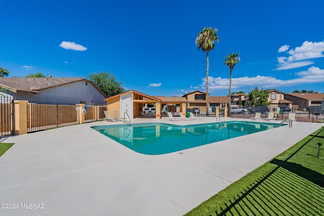 view of pool with a lawn and a patio area