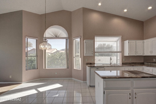 kitchen featuring dark stone countertops, sink, dishwasher, and white cabinets