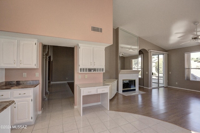 kitchen featuring lofted ceiling, ceiling fan, white cabinets, and light wood-type flooring