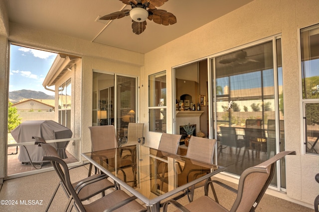 sunroom / solarium featuring ceiling fan and a mountain view