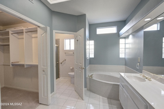 bathroom featuring tile patterned flooring, a bath, vanity, and toilet