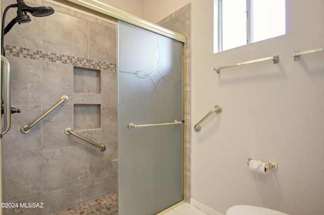 bathroom with toilet and a shower with door