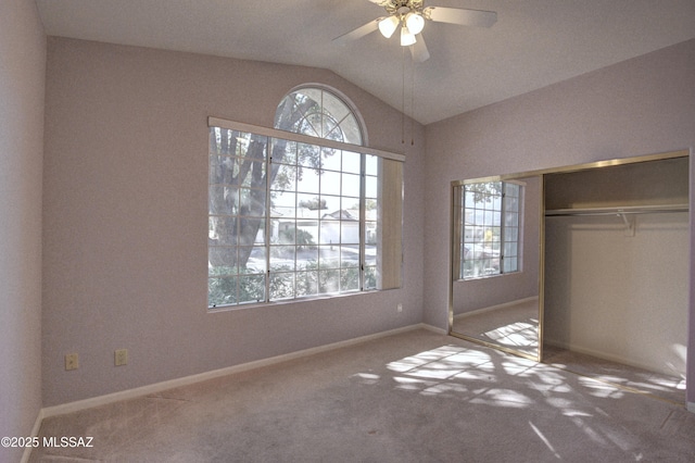 unfurnished bedroom featuring ceiling fan, carpet flooring, vaulted ceiling, and a closet