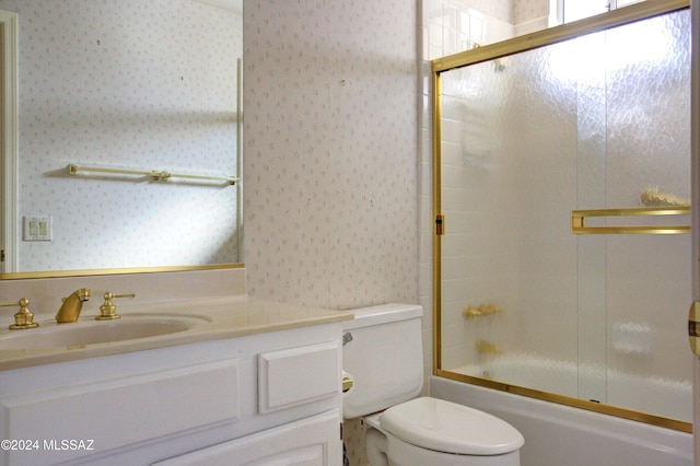 full bathroom with vanity, shower / bath combination with glass door, and toilet