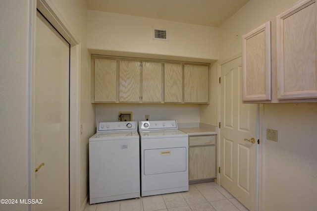 laundry area with light tile patterned flooring, cabinets, and washer and clothes dryer