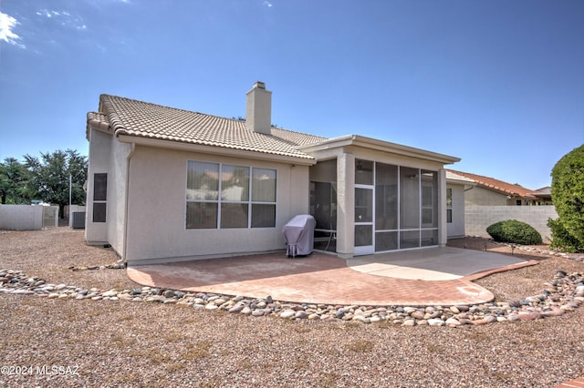 back of property with a sunroom and a patio