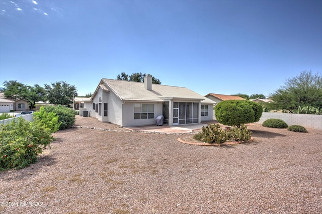 rear view of property featuring a sunroom and a patio area