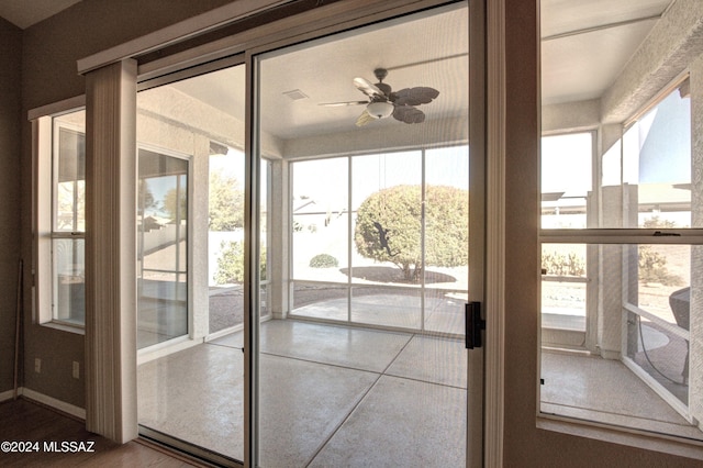 unfurnished sunroom with ceiling fan