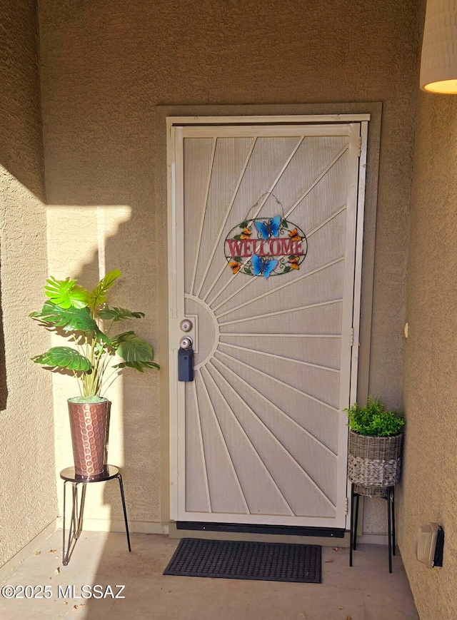 property entrance with stucco siding