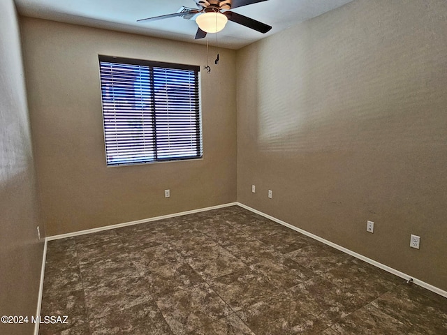 unfurnished room with ceiling fan and baseboards