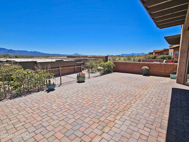 view of patio / terrace featuring fence and a mountain view