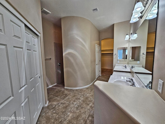 bathroom with double vanity, a closet, visible vents, and a sink