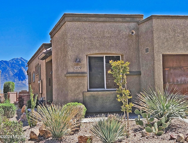 view of home's exterior with a mountain view and stucco siding