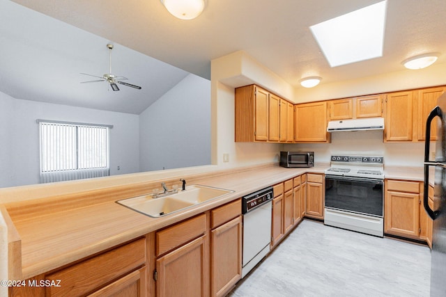 kitchen with white appliances, kitchen peninsula, lofted ceiling with skylight, ceiling fan, and sink