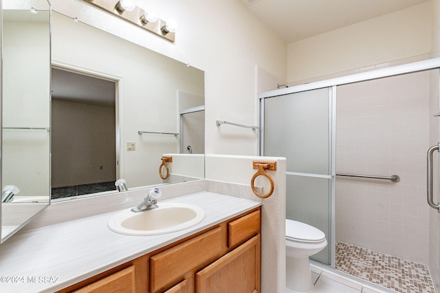 bathroom featuring walk in shower, vanity, toilet, and tile patterned floors